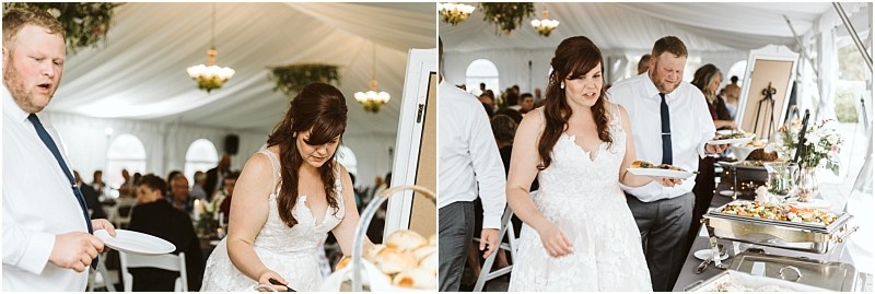 Premier Snohomish & Seattle Wedding Photographer | GSquared Weddings Photography A bride and guests in formal attire serve themselves food from a buffet table under a white tent at a lively and festive Snohomish wedding reception, with decorated tables in the background. 47.9129° N, 122.0982° W | Serving Snohomish, Seattle , Orlando & Beyond