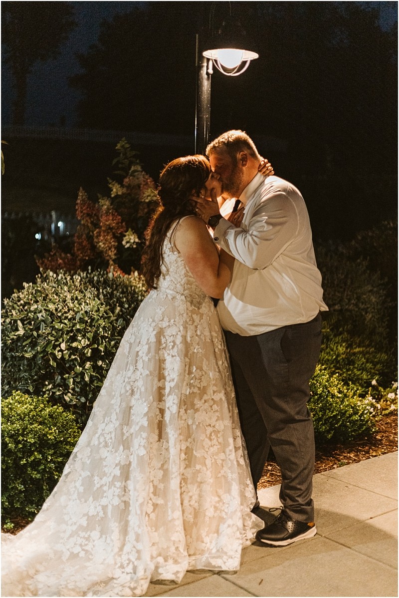 Premier Snohomish & Seattle Wedding Photographer | GSquared Weddings Photography A bride in a lace wedding dress and a groom in a white shirt and dark pants stand close, touching foreheads and holding hands, under a glowing streetlamp at night in a Snohomish garden—capturing true Seattle wedding romance. 47.9129° N, 122.0982° W | Serving Snohomish, Seattle , Orlando & Beyond