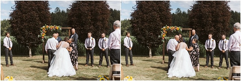 Premier Snohomish & Seattle Wedding Photographer | GSquared Weddings Photography A bride in a white dress stands outdoors with a woman, facing a groom and groomsmen in dress shirts and ties, near a floral arch and green trees under a partly cloudy sky at this romantic Snohomish Seattle wedding. 47.9129° N, 122.0982° W | Serving Snohomish, Seattle , Orlando & Beyond