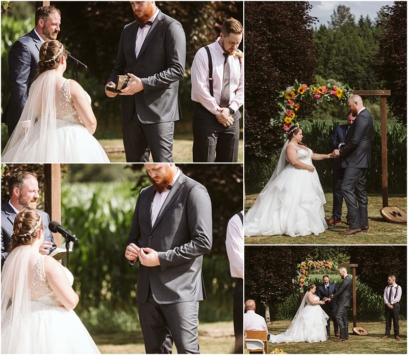 Premier Snohomish & Seattle Wedding Photographer | GSquared Weddings Photography A bride and groom exchange rings and vows outdoors beneath a floral arch at a Snohomish Seattle wedding, with an officiant and groomsman beside them. Sunlight filters through the trees as the bride in her white gown faces the groom in his gray suit. 47.9129° N, 122.0982° W | Serving Snohomish, Seattle , Orlando & Beyond