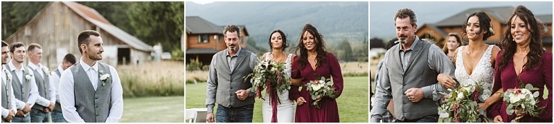 Premier Snohomish & Seattle Wedding Photographer | GSquared Weddings Photography A groom and groomsmen wait outside; a bride in white walks down the aisle at a rustic Snohomish wedding, accompanied by two people—one in a gray vest, one in a burgundy dress—holding bouquets, with charming buildings in the background. 47.9129° N, 122.0982° W | Serving Snohomish, Seattle , Orlando & Beyond