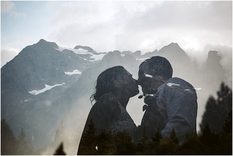 Premier Snohomish & Seattle Wedding Photographer | GSquared Weddings Photography A double exposure photo of a couple about to kiss, holding a flower between them, with misty, snow-topped mountains and pine trees in the background, capturing the romantic spirit of a Snohomish Seattle wedding engagement. 47.9129° N, 122.0982° W | Serving Snohomish, Seattle , Orlando & Beyond