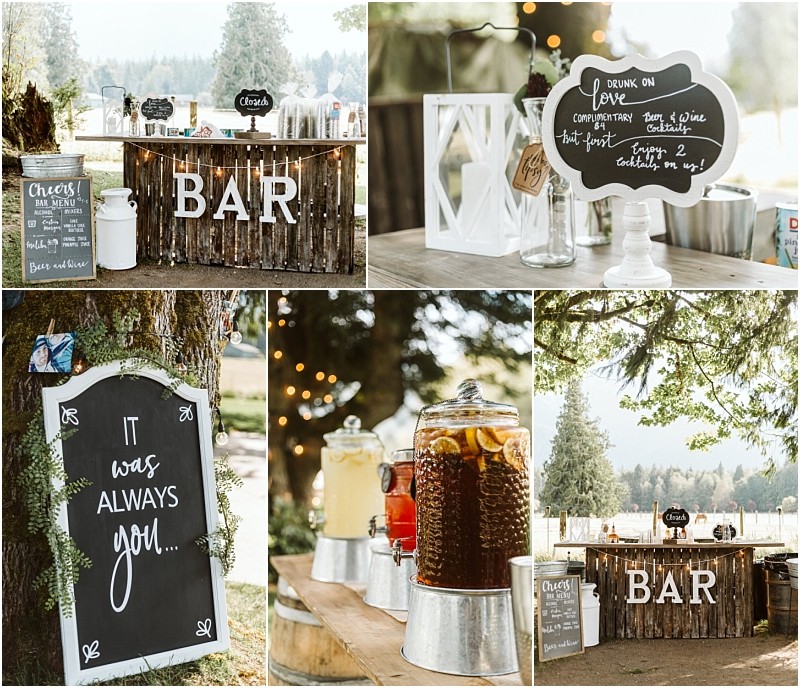 Premier Snohomish & Seattle Wedding Photographer | GSquared Weddings Photography A rustic outdoor bar setup with a wooden bar, chalkboard signs, drinks in glass dispensers, and decorative lanterns under trees—perfect for a Snohomish or Seattle wedding or engagement, set against mountains and lush greenery. 47.9129° N, 122.0982° W | Serving Snohomish, Seattle , Orlando & Beyond