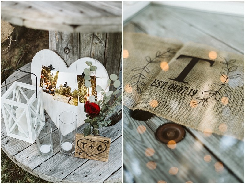 Premier Snohomish & Seattle Wedding Photographer | GSquared Weddings Photography A rustic Snohomish wedding decor display features a wooden spool table with a heart-shaped photo frame, white lantern, glass vases, a red rose, and a burlap sign with T EST. 10 19, surrounded by leaves and fairy lights. 47.9129° N, 122.0982° W | Serving Snohomish, Seattle , Orlando & Beyond
