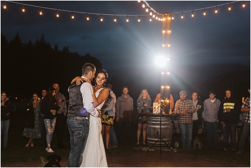 Premier Snohomish & Seattle Wedding Photographer | GSquared Weddings Photography A bride and groom share their first dance outdoors at night under string lights at their Snohomish wedding, surrounded by guests who watch and smile. The scene is warmly lit and festive with a rustic, casual atmosphere. 47.9129° N, 122.0982° W | Serving Snohomish, Seattle , Orlando & Beyond