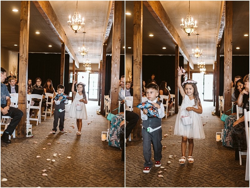 Premier Snohomish & Seattle Wedding Photographer | GSquared Weddings Photography At a Snohomish wedding, two children walk down the aisle; a young boy in a vest tosses petals, while a girl in a white dress and flower crown smiles and waves. Guests seated in white chairs watch and smile. 47.9129° N, 122.0982° W | Serving Snohomish, Seattle , Orlando & Beyond