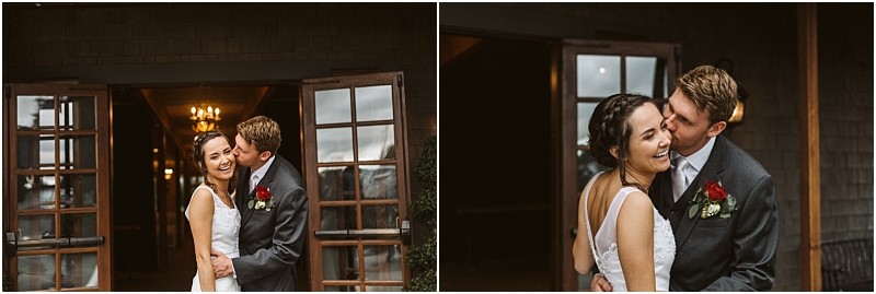 Premier Snohomish & Seattle Wedding Photographer | GSquared Weddings Photography A bride and groom stand smiling and embracing outside a building with wooden doors and warm light inside. The groom kisses the bride on the cheek as they both laugh, celebrating their Snohomish wedding day. 47.9129° N, 122.0982° W | Serving Snohomish, Seattle , Orlando & Beyond