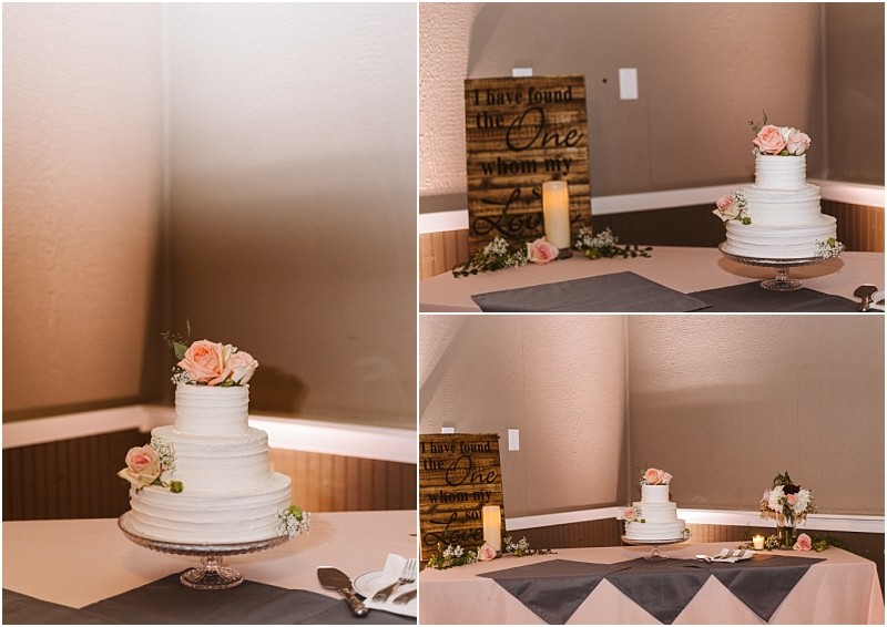 Premier Snohomish & Seattle Wedding Photographer | GSquared Weddings Photography A three-tier white wedding cake with pink roses on top sits on a glass stand at a Snohomish Seattle Wedding. Behind it is a wooden sign, candle, and floral decorations, creating the perfect engagement celebration scene. 47.9129° N, 122.0982° W | Serving Snohomish, Seattle , Orlando & Beyond