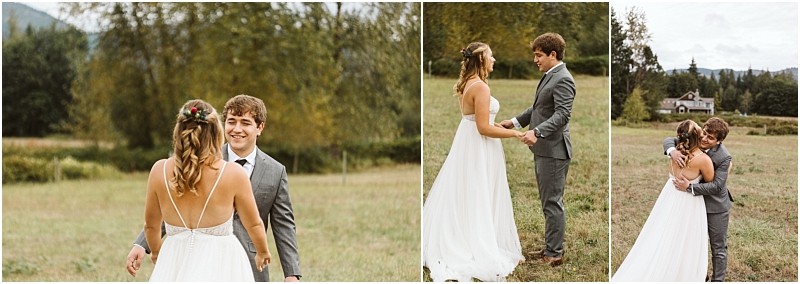 Premier Snohomish & Seattle Wedding Photographer | GSquared Weddings Photography A bride and groom stand in a grassy field near Snohomish, smiling and holding hands on their wedding day. The bride wears a white dress with a floral hairpiece, and the groom wears a gray suit. Trees and a house are visible in the background. 47.9129° N, 122.0982° W | Serving Snohomish, Seattle , Orlando & Beyond