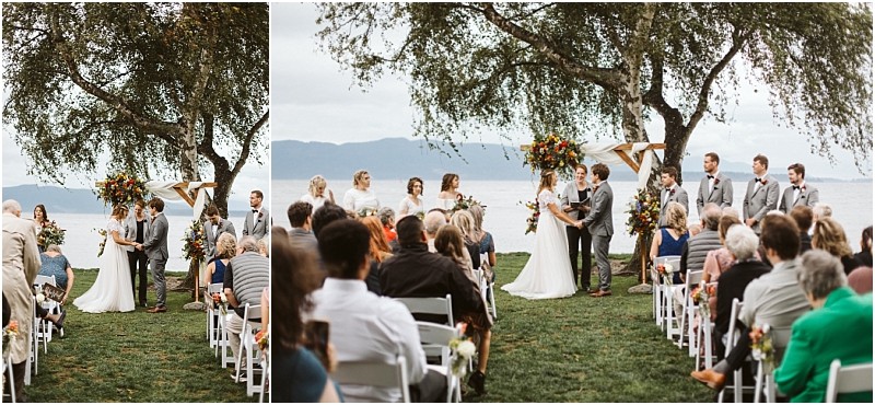 Premier Snohomish & Seattle Wedding Photographer | GSquared Weddings Photography An outdoor Snohomish wedding ceremony by the water; the bride and groom stand under a floral arch with their bridal party, while guests watch from white chairs on the grass. Trees and mountains frame this stunning Seattle engagement setting. 47.9129° N, 122.0982° W | Serving Snohomish, Seattle , Orlando & Beyond