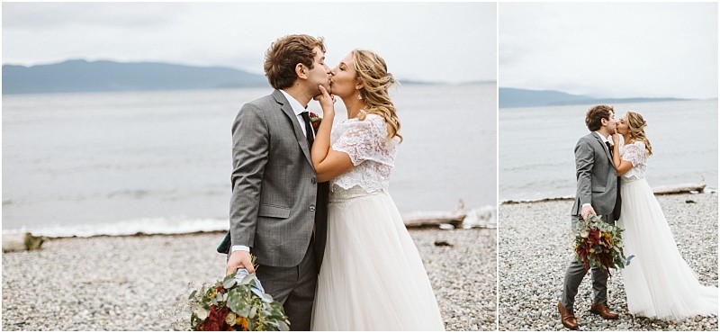 Premier Snohomish & Seattle Wedding Photographer | GSquared Weddings Photography A bride and groom share a kiss on a rocky beach near Snohomish, with the ocean and mountains behind them. The groom, in a gray suit holding a bouquet, stands with his bride in a white gown under the cloudy Seattle sky. 47.9129° N, 122.0982° W | Serving Snohomish, Seattle , Orlando & Beyond