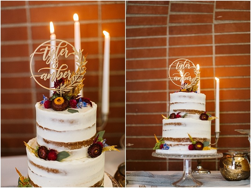 Premier Snohomish & Seattle Wedding Photographer | GSquared Weddings Photography A two-tier semi-naked cake, perfect for a Snohomish or Seattle wedding, is decorated with flowers and greenery on a glass stand. The topper reads tyler & amber, with glowing candles against a brick wall in the background. 47.9129° N, 122.0982° W | Serving Snohomish, Seattle , Orlando & Beyond