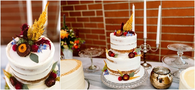 Premier Snohomish & Seattle Wedding Photographer | GSquared Weddings Photography A three-tiered semi-naked cake decorated with dried flowers and grasses sits on a glass stand, surrounded by candles and floral arrangements—perfect for a Snohomish or Seattle wedding or engagement celebration against a rustic brick wall. 47.9129° N, 122.0982° W | Serving Snohomish, Seattle , Orlando & Beyond