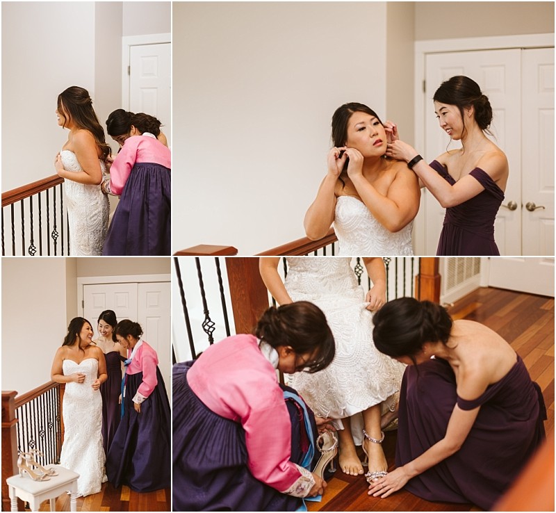 Premier Snohomish & Seattle Wedding Photographer | GSquared Weddings Photography A bride in a strapless white gown gets ready for her Snohomish Seattle wedding, helped by two women—one in a purple dress and one in a pink and purple hanbok—assisting with earrings, her dress, and shoes on a wooden staircase indoors. 47.9129° N, 122.0982° W | Serving Snohomish, Seattle , Orlando & Beyond