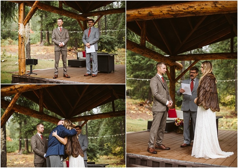 Premier Snohomish & Seattle Wedding Photographer | GSquared Weddings Photography A bride in a fur shawl and a groom in a brown suit stand with an officiant on a wooden outdoor stage in a forest. This Snohomish wedding unfolds as the couple listens, hugs, and exchanges vows beneath a rustic wooden pavilion. 47.9129° N, 122.0982° W | Serving Snohomish, Seattle , Orlando & Beyond