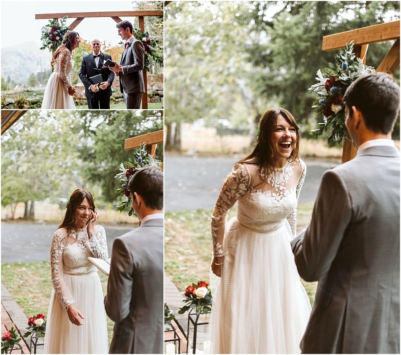 Premier Snohomish & Seattle Wedding Photographer | GSquared Weddings Photography A bride in a white, long-sleeved lace dress and a groom in a gray suit exchange vows outdoors at their Snohomish wedding, smiling and laughing joyfully under a wooden arch adorned with flowers. 47.9129° N, 122.0982° W | Serving Snohomish, Seattle , Orlando & Beyond