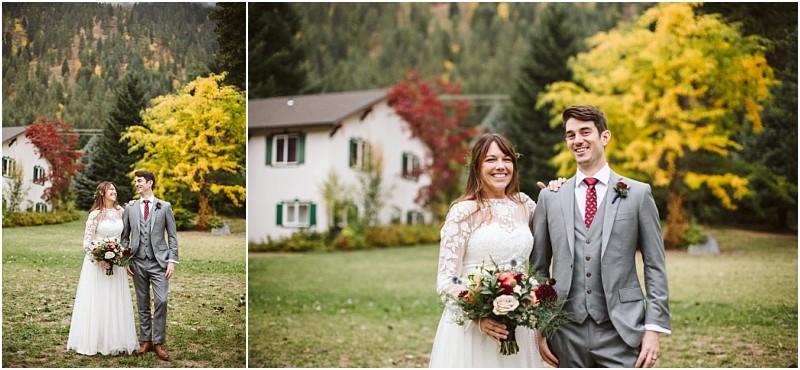 Premier Snohomish & Seattle Wedding Photographer | GSquared Weddings Photography A bride in a white lace dress and a groom in a gray suit with a red tie stand smiling outside on a lawn, capturing their Snohomish wedding joy amid colorful autumn trees and a white house in the background. 47.9129° N, 122.0982° W | Serving Snohomish, Seattle , Orlando & Beyond