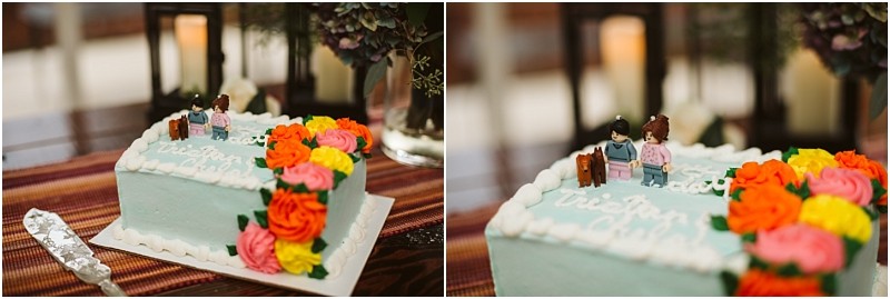 Premier Snohomish & Seattle Wedding Photographer | GSquared Weddings Photography A rectangular cake with blue icing, white frosting borders, and colorful buttercream flowers. Two LEGO-style figurines stand on top—perfect for a Snohomish or Seattle wedding or engagement celebration. A cake server rests nearby on a striped tablecloth. 47.9129° N, 122.0982° W | Serving Snohomish, Seattle , Orlando & Beyond