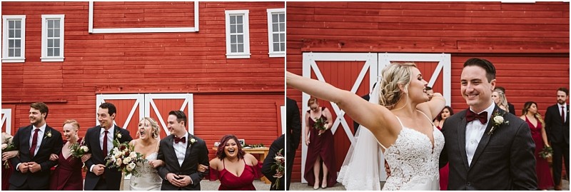 Premier Snohomish & Seattle Wedding Photographer | GSquared Weddings Photography A wedding party poses in front of a large red barn during a joyful Snohomish Seattle wedding. On the left, the group smiles and walks together; on the right, the bride extends her arms beside the groom, with bridesmaids and groomsmen in the background. 47.9129° N, 122.0982° W | Serving Snohomish, Seattle , Orlando & Beyond