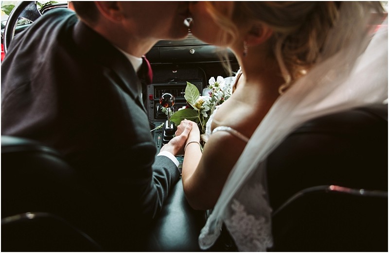 Premier Snohomish & Seattle Wedding Photographer | GSquared Weddings Photography A bride and groom share a kiss while sitting in a car, holding hands. The bride wears a veil and white dress, holding a bouquet of flowers. Captured from behind, this intimate Snohomish wedding moment feels truly romantic. 47.9129° N, 122.0982° W | Serving Snohomish, Seattle , Orlando & Beyond
