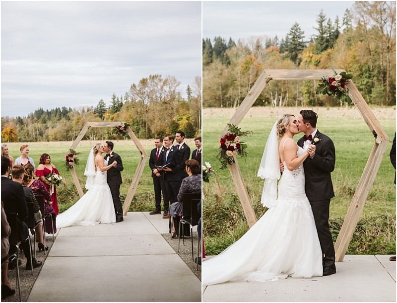 Premier Snohomish & Seattle Wedding Photographer | GSquared Weddings Photography A bride and groom share a kiss at their Snohomish outdoor wedding ceremony, standing under a wooden hexagon arch adorned with flowers. Guests are seated on either side, with autumn trees adding romance to this Seattle-area celebration. 47.9129° N, 122.0982° W | Serving Snohomish, Seattle , Orlando & Beyond