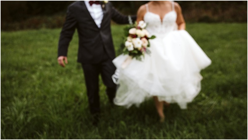 Premier Snohomish & Seattle Wedding Photographer | GSquared Weddings Photography A blurry photo of a bride in a white wedding dress holding a bouquet, walking alongside a person in a dark suit on green grass at a Snohomish Seattle wedding. 47.9129° N, 122.0982° W | Serving Snohomish, Seattle , Orlando & Beyond