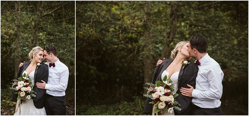 Premier Snohomish & Seattle Wedding Photographer | GSquared Weddings Photography A bride and groom stand close in a wooded area at their Snohomish wedding. The groom kisses the bride as she wears his jacket over her dress and holds a bouquet of white and blush flowers. Both appear happy and in love. 47.9129° N, 122.0982° W | Serving Snohomish, Seattle , Orlando & Beyond