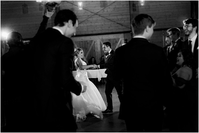 Premier Snohomish & Seattle Wedding Photographer | GSquared Weddings Photography A bride and groom share a joyful dance at their Snohomish wedding reception, surrounded by elegantly dressed guests. The black and white photo captures a timeless Seattle celebration on the dance floor. 47.9129° N, 122.0982° W | Serving Snohomish, Seattle , Orlando & Beyond