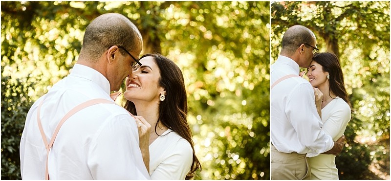 Premier Snohomish & Seattle Wedding Photographer | GSquared Weddings Photography A couple embraces outdoors in soft sunlight during their Snohomish Seattle engagement. The woman smiles with her eyes closed as the man gently holds her, both dressed in light-colored clothing, surrounded by lush green foliage. 47.9129° N, 122.0982° W | Serving Snohomish, Seattle , Orlando & Beyond