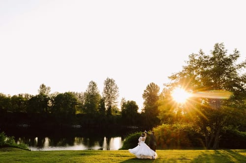 A couple in wedding attire dances on a grassy lawn near a river at sunset the sun casting a warm glowperfect inspiration for couples searching for scenic Washington wedding venues Snohomish Wedding Photography A couple in wedding attire dances on a grassy lawn near a river at sunset the sun casting a warm glowperfect inspiration for couples searching for scenic Washington wedding venues Snohomish Wedding Photography