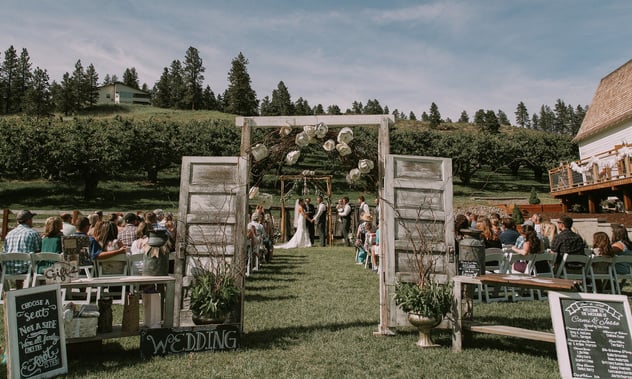 Hampton Hideaway ceremony area with orchard and doors near the white barn