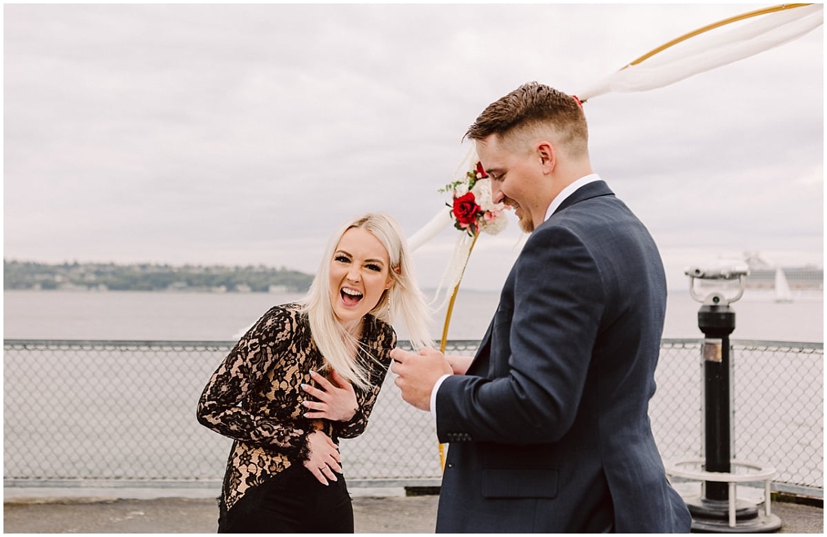 seattle proposal on pier 70 man and woman with puget sound and ferries behind them wedding proposal near the olympic sculpture park