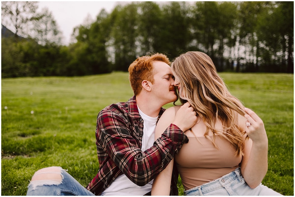 meadowbrook farm engagement session bride and groom sitting on the grass snuggled up