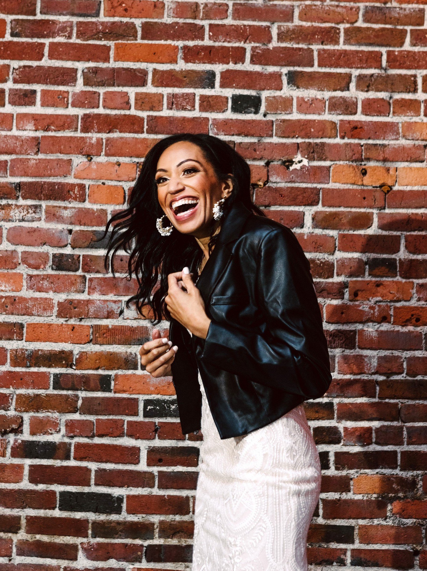 SeattleBelltownWeddingPhotographyBride Seattle Belltown Wedding Photography of a Black Woman wearing a wedding gown and leather jacket laughing by GSquared Weddings Photography