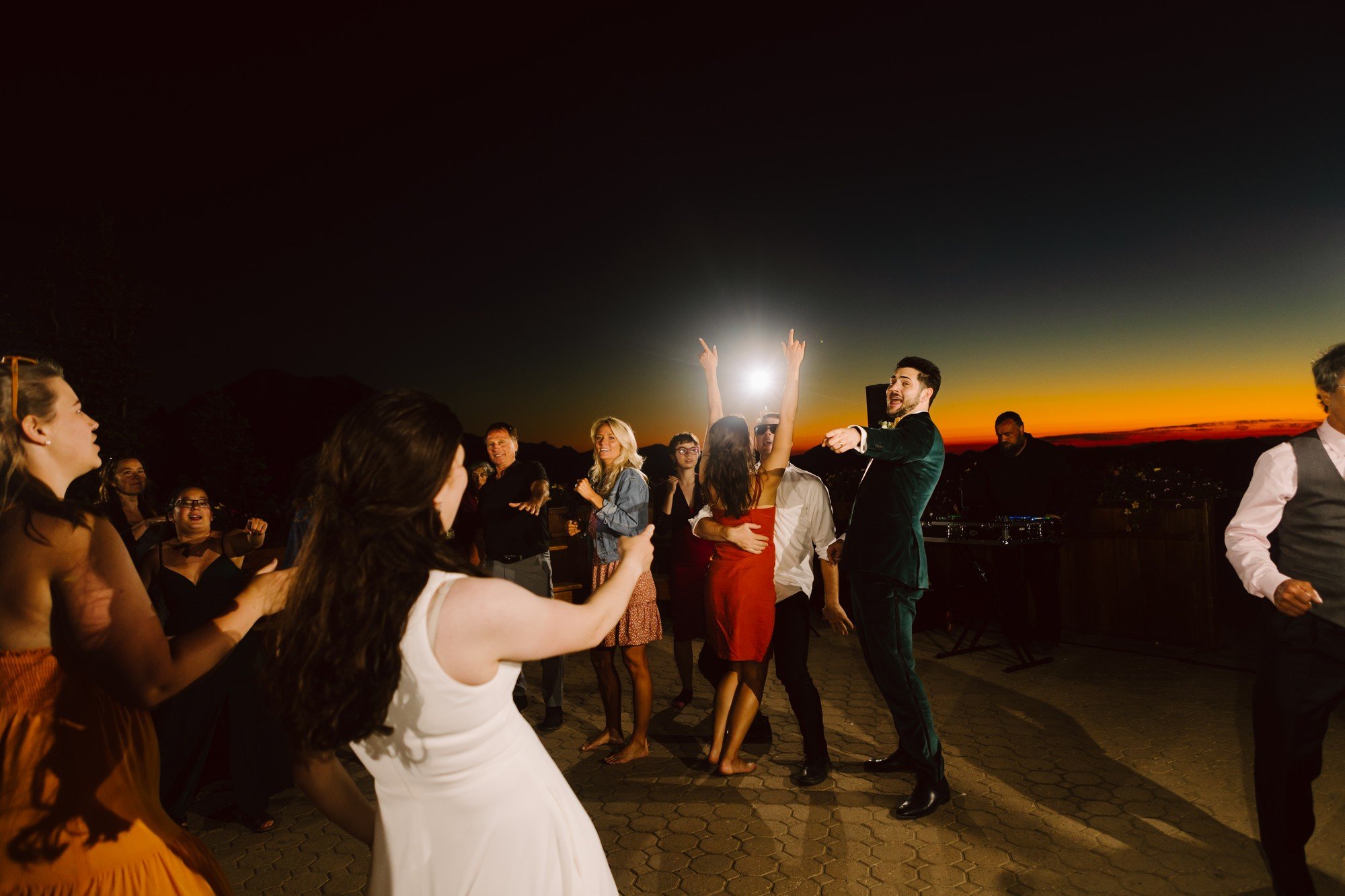 crystal mountain wedding reception micro wedding intentional small guest list bride and groom dancing with guests in a beautiful sunset at mount rainier