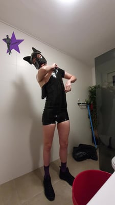 Rubber pup locked inside a carrara with a tail plug in his ass