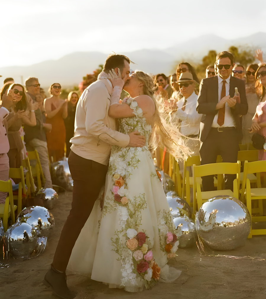 First kiss at desert ceremony with floral dress and disco ball decorations at Bubbling Wells Oasis