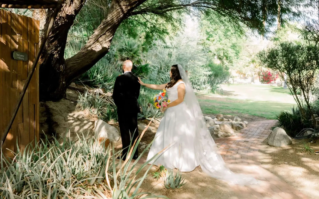 Wedding couple walking through the desert landscape at Bubbling Wells Oasis