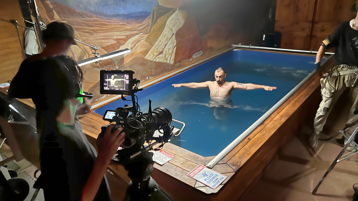 Film crew shooting actor in natural hot springs pool