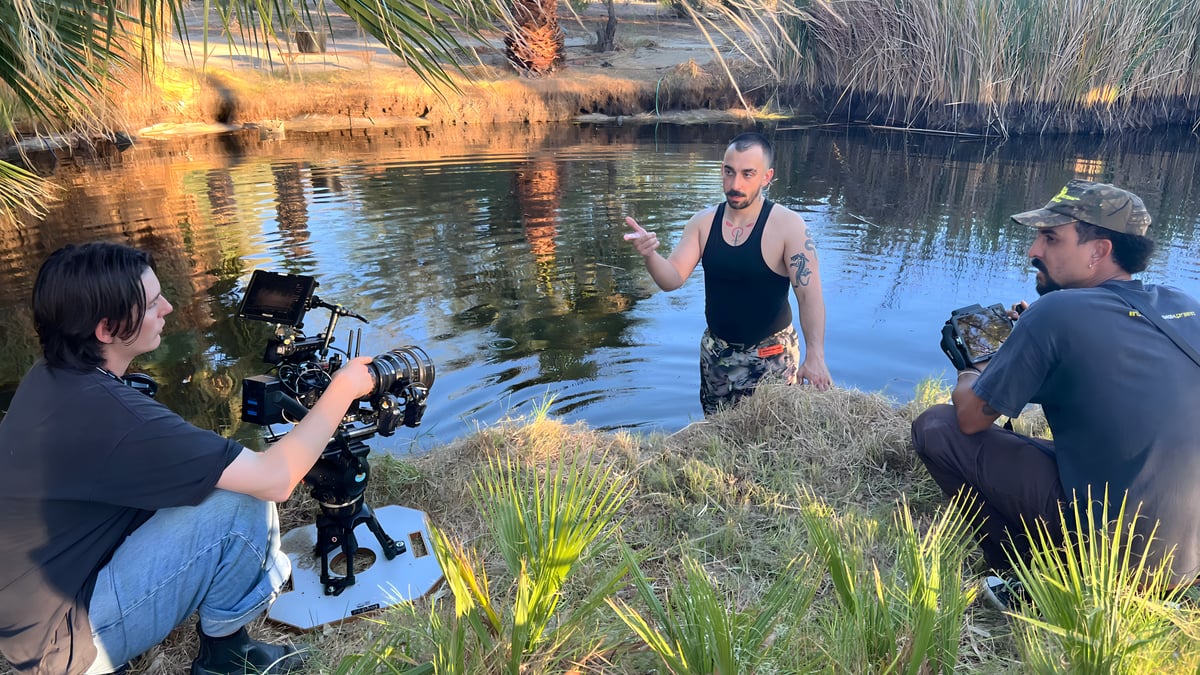 Film production crew filming by natural hot springs lake