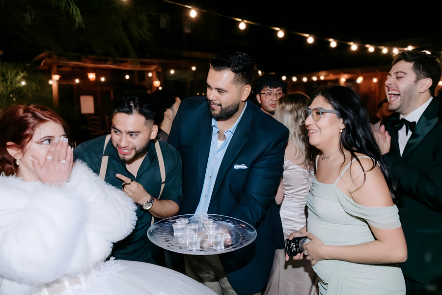 Wedding reception celebration with guests and string lights at night