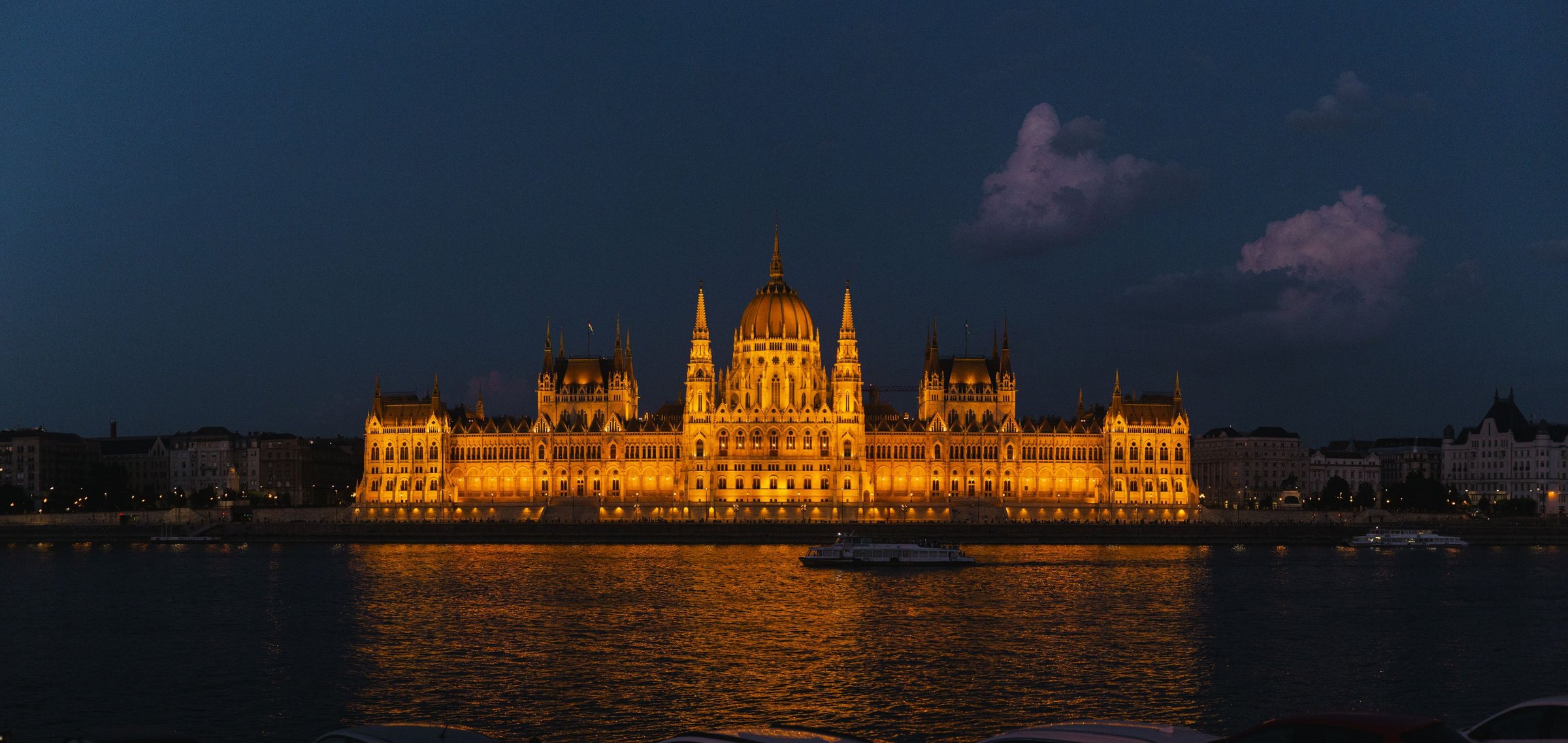 Gedung Parlemen Budapest di tepi Sungai Danube saat malam.