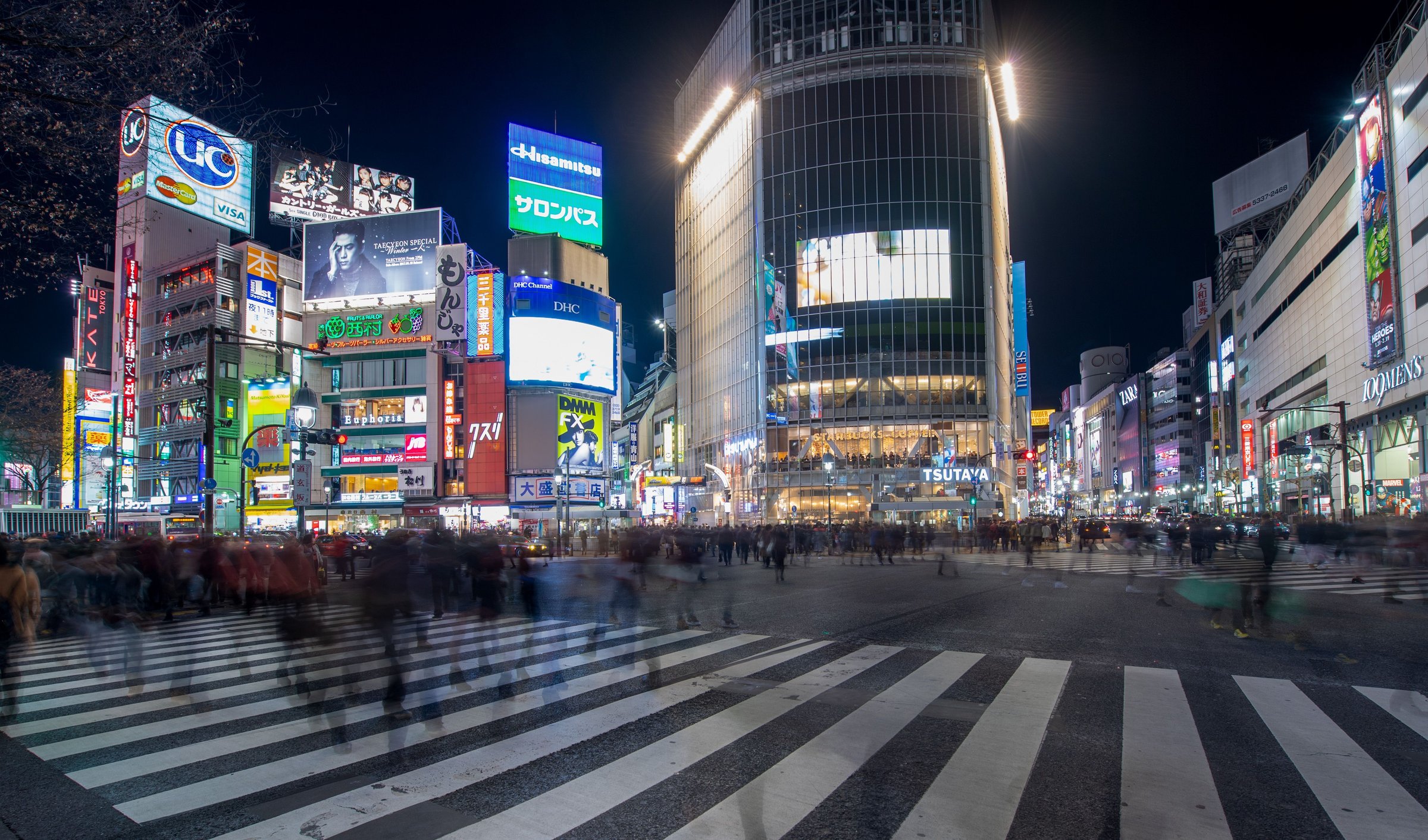 Persimpangan Shibuya Tokyo dipadati pejalan kaki malam hari berlatar lampu neon papan reklame