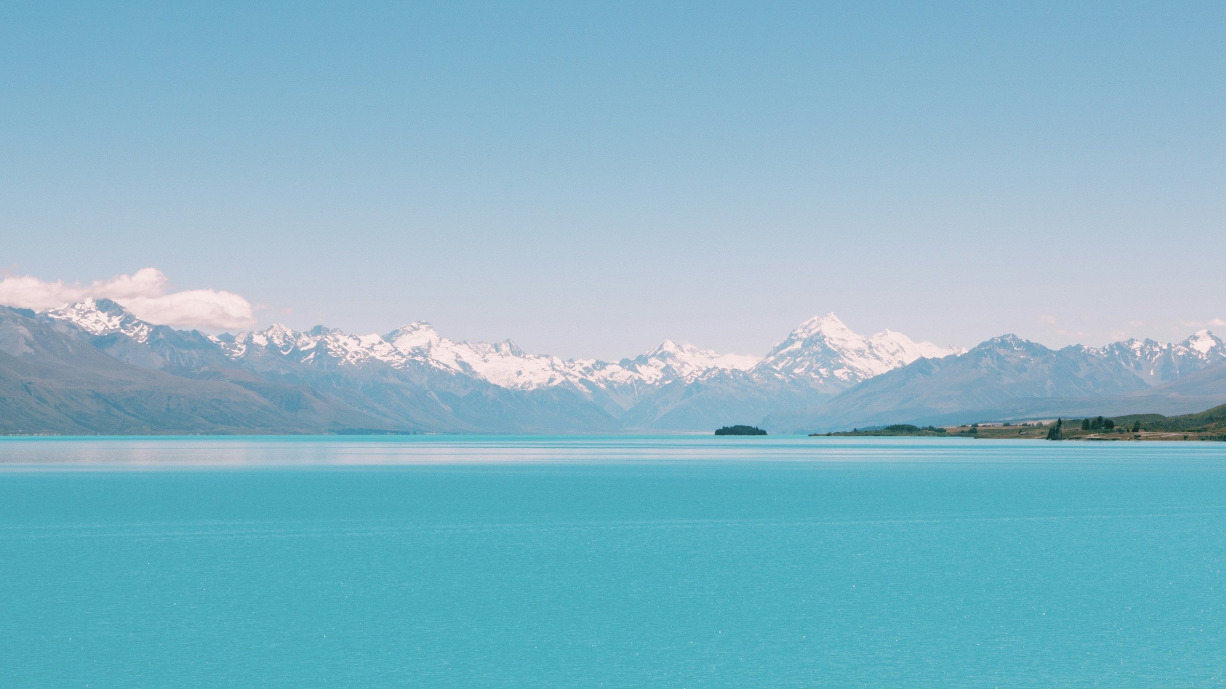 Danau Pukaki berwarna toska dengan Aoraki/Mount Cook bersalju di kejauhan.