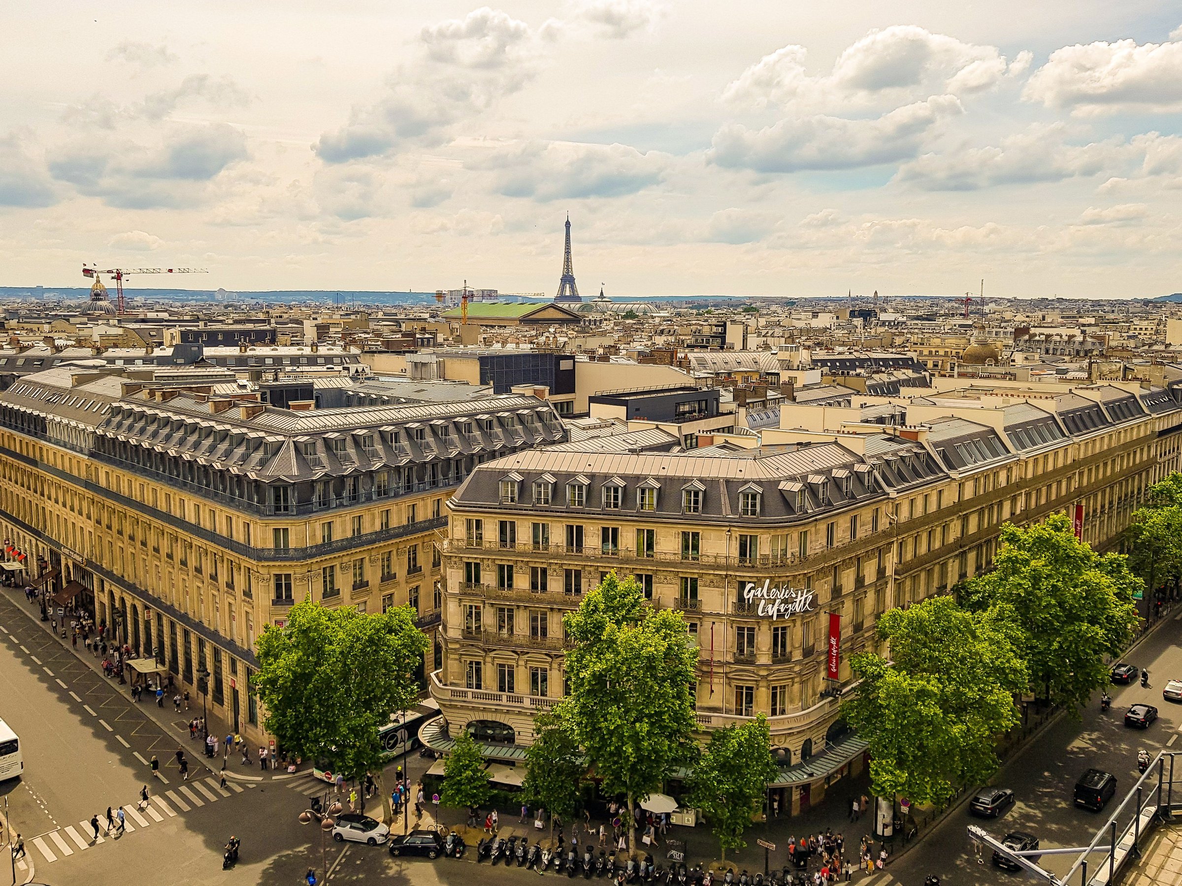 Bangunan Galeries Lafayette bergaya klasik Paris dengan Menara Eiffel tampak di kejauhan