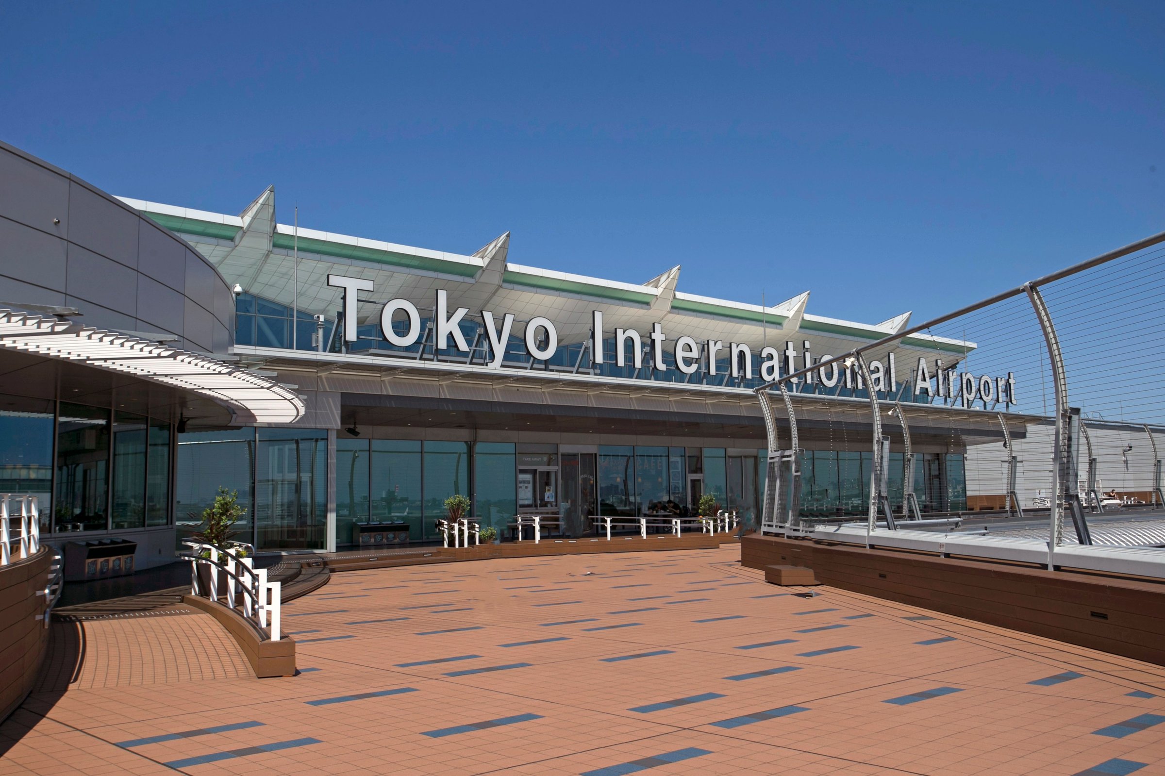 Fasad Bandara Internasional Tokyo dengan langit biru cerah tanpa awan