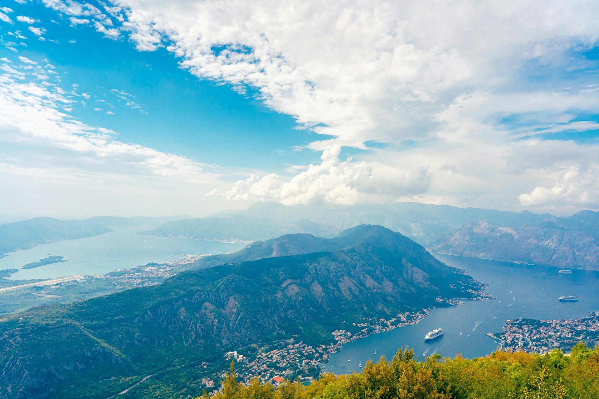 Pemandangan aerial Teluk Kotor Montenegro fjord dikelilingi pegunungan curam dengan kota tua di tepi air
