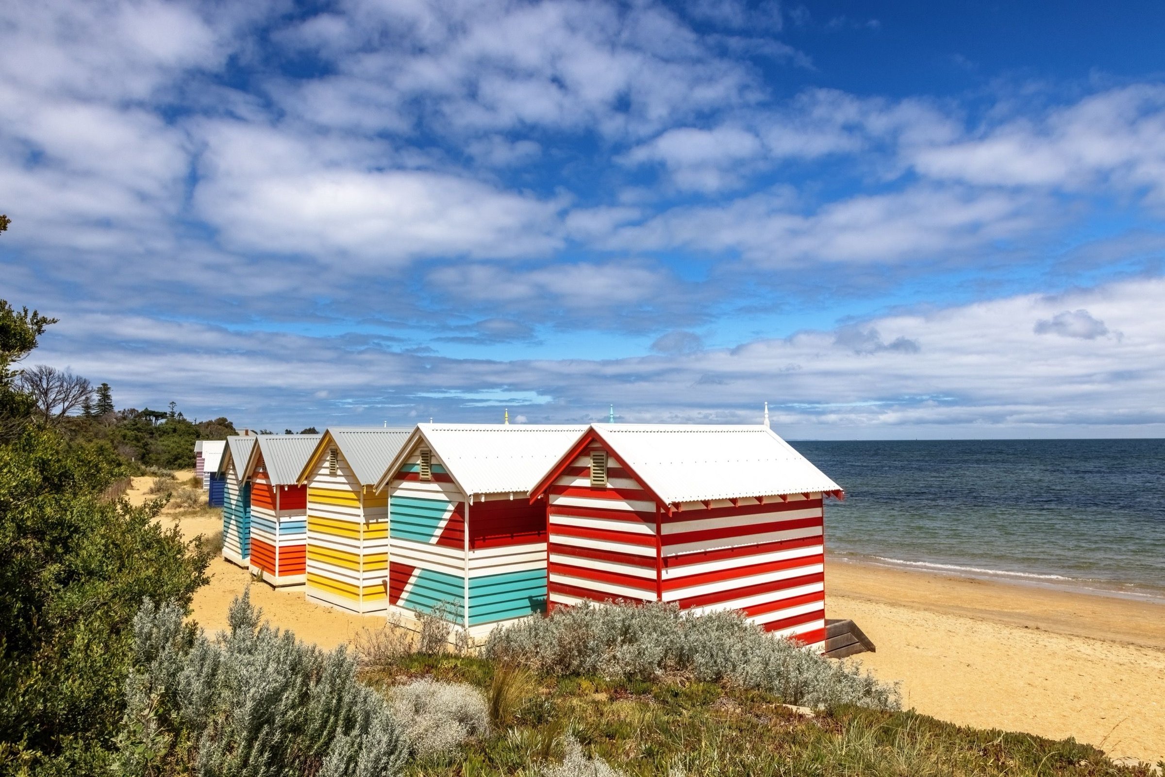 Deretan rumah pantai kayu warna-warni Brighton Bathing Boxes di tepi pasir Melbourne