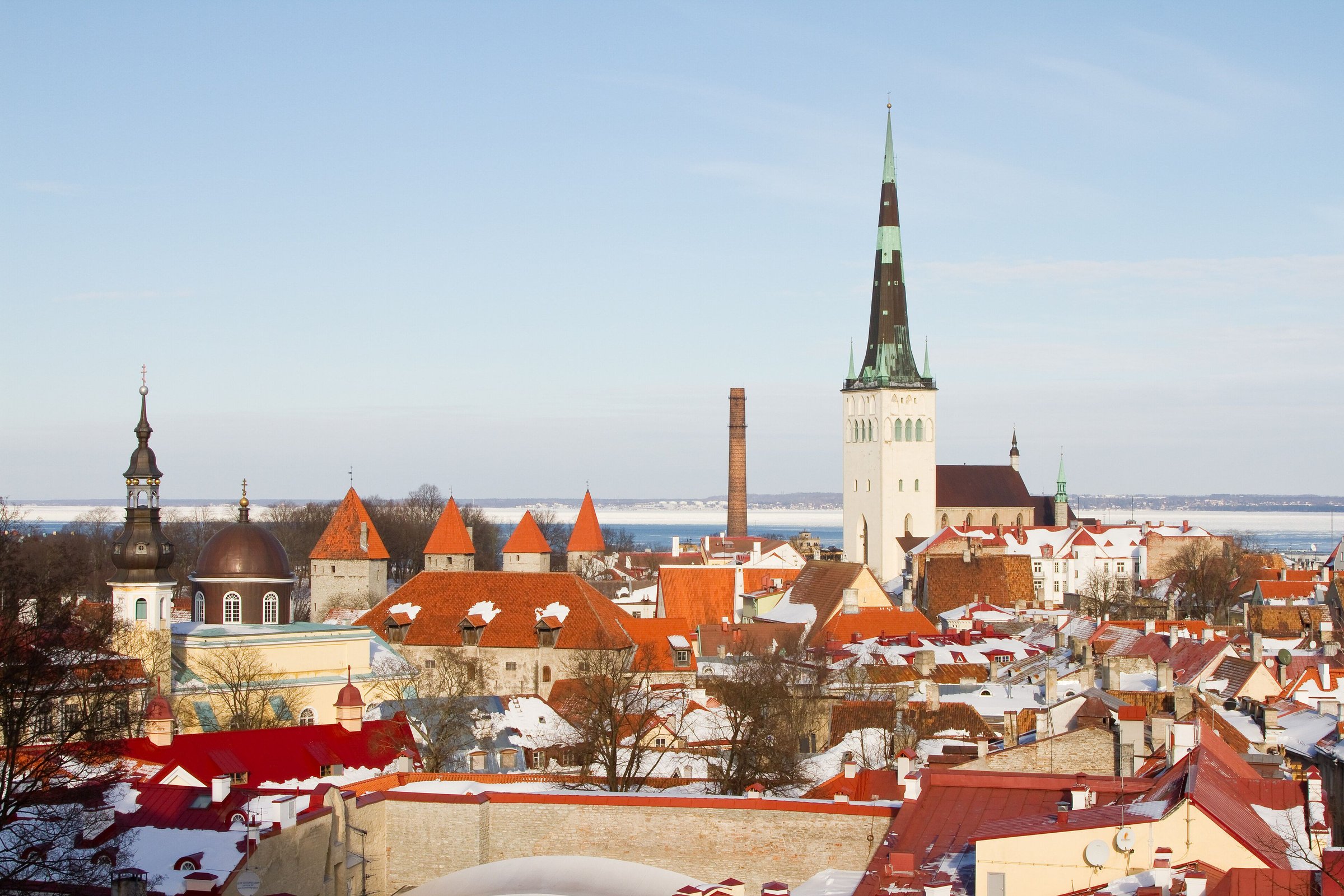 Atap merah kota tua Tallinn dan menara gereja St Olaf dengan sedikit salju