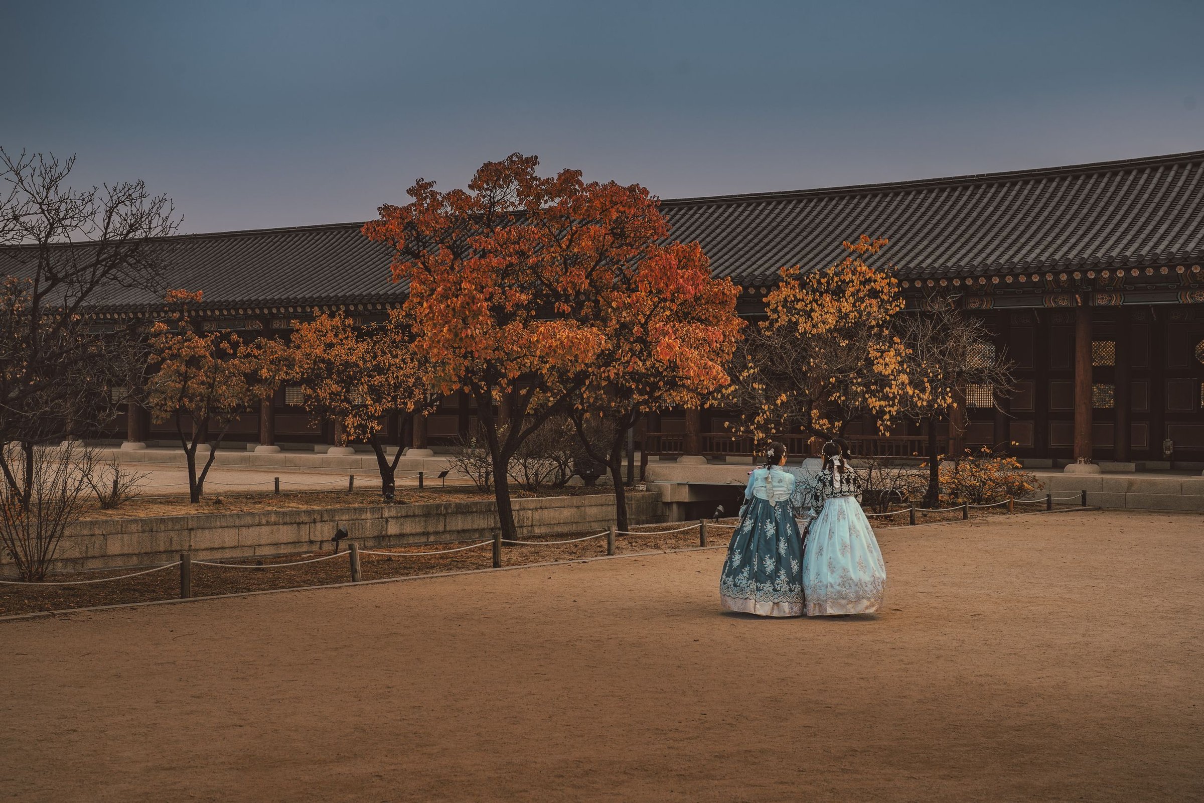 Dua wanita berhanbok di Istana Gyeongbokgung saat musim gugur